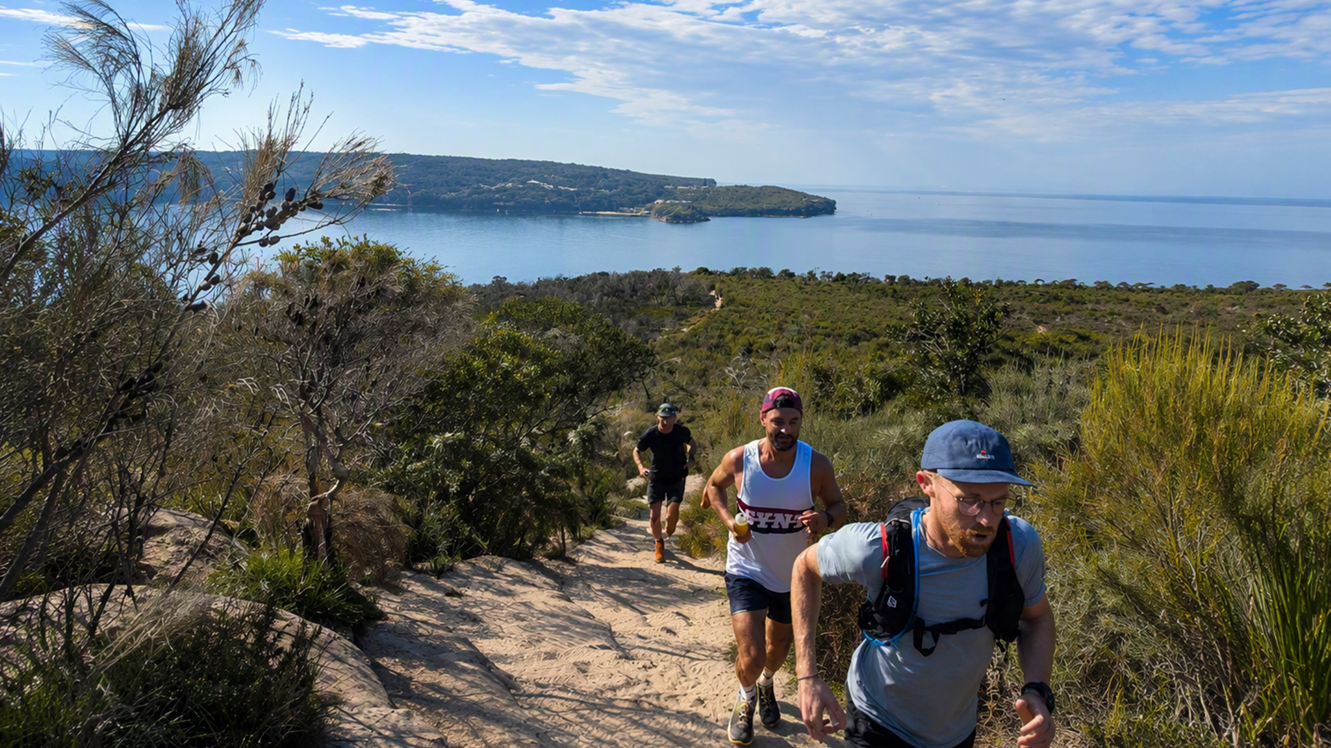 Trail runners climbing above Sydney Harbour on the Manly to Spit route